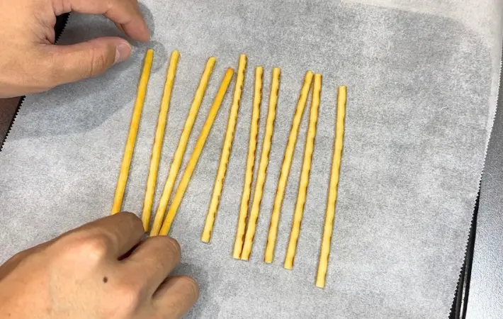 耐熱皿にクッキングシートを敷き、プリッツを乗せる（撮影：キジカク）