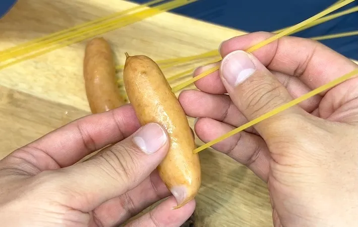 ソーセージにパスタを刺している画像（撮影：キジカク）