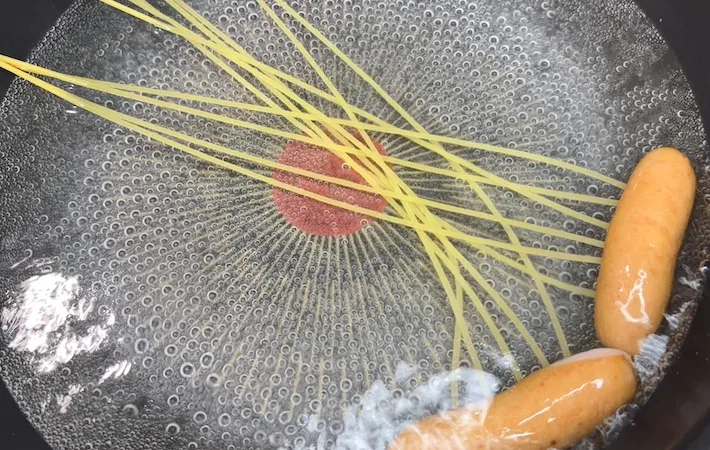 パスタを刺したウインナーを茹でている画像（撮影：キジカク）