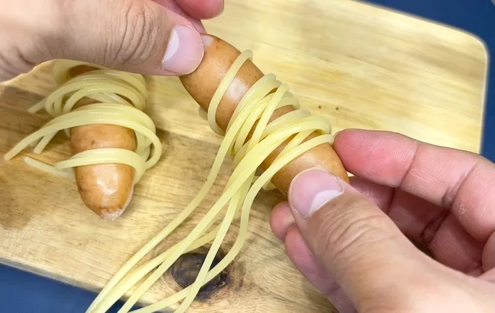 ソーセージにパスタを巻いている画像（撮影：キジカク）