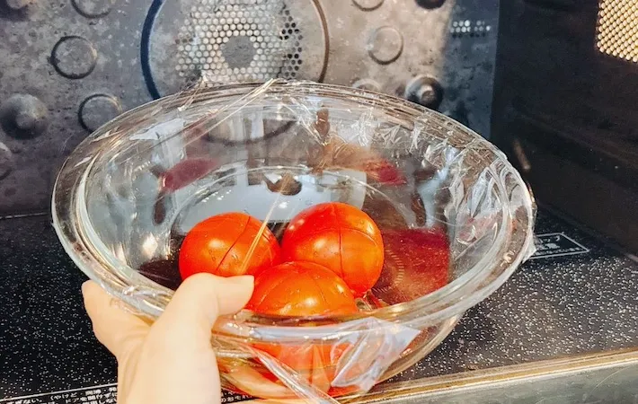 切り込みを入れたトマトを電子レンジに入れている画像（撮影：キジカク）
