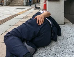 泥酔して道路で寝る人の写真