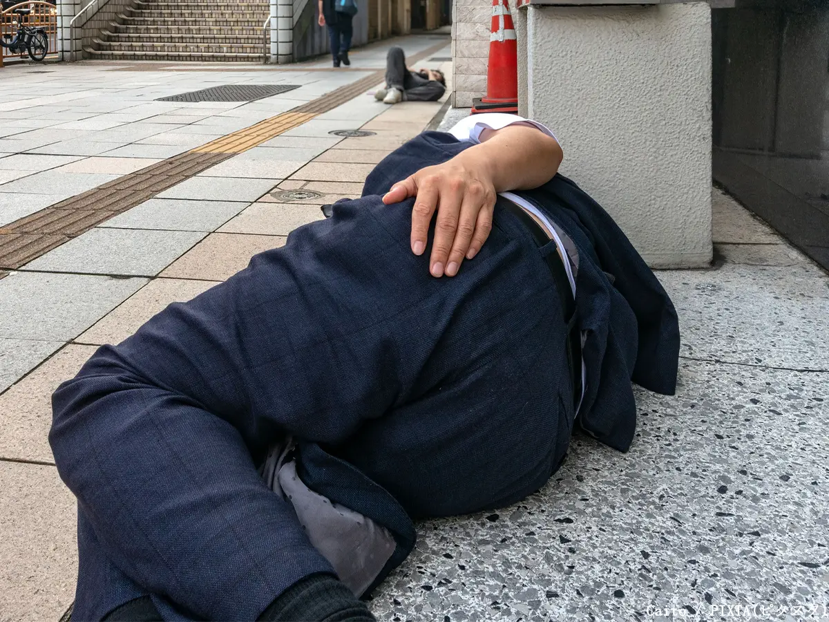 泥酔して道路で寝る人の写真