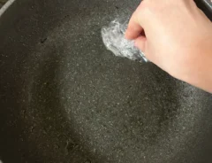 ラップでフライパンの油汚れを拭き取る写真（撮影：grapeライフハック編集部）