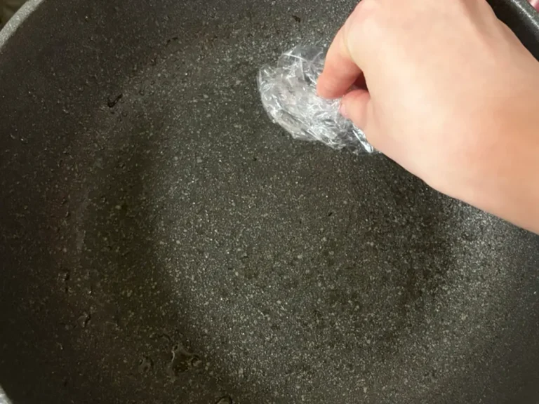 ラップでフライパンの油汚れを拭き取る写真(撮影:grapeライフハック編集部)