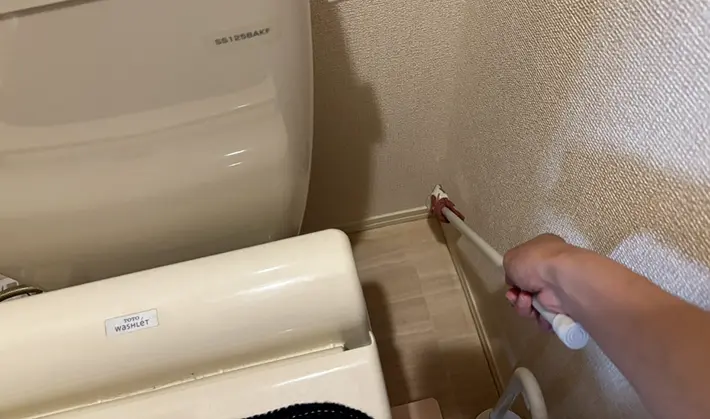 つっぱり棒を使ってトイレ掃除をしている画像（撮影：grapeライフハック編集部）