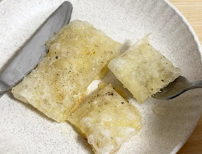 スライスチーズをライスペーパーで包んで焼いた料理を食べる写真（撮影：grapeフード編集部）