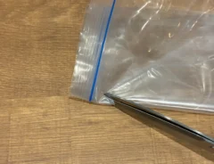 ジッパー袋のジッパー下をハサミで切り取る場面（撮影：grapeライフハック編集部）