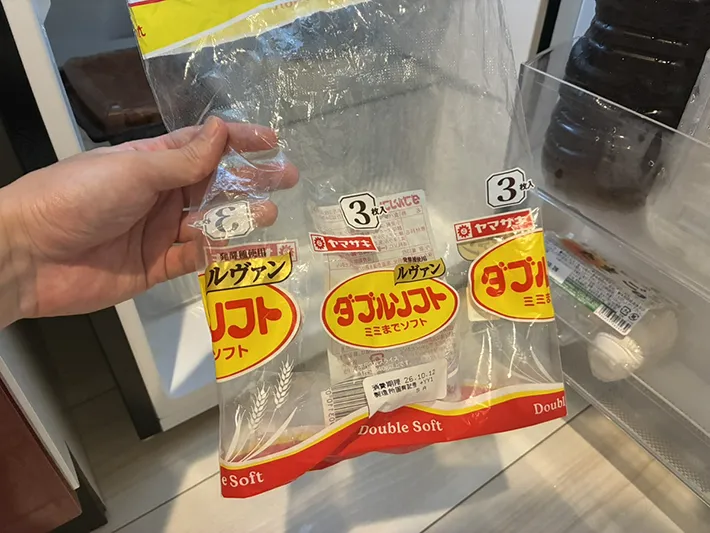 冷蔵庫の前で手にする食パン袋（撮影：grapeライフハック編集部）
