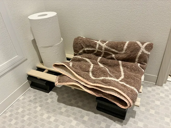 すのこの上にのせたトイレットペーパーとバスタオル（撮影：grapeライフハック編集部）