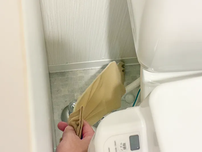ハンガーにつけたストッキングでトイレの床を掃除する場面（撮影：grapeライフハック編集部）