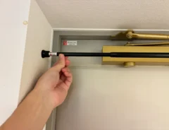 玄関のドア上につっぱり棒を設置する場面（撮影：grapeライフハック編集部）