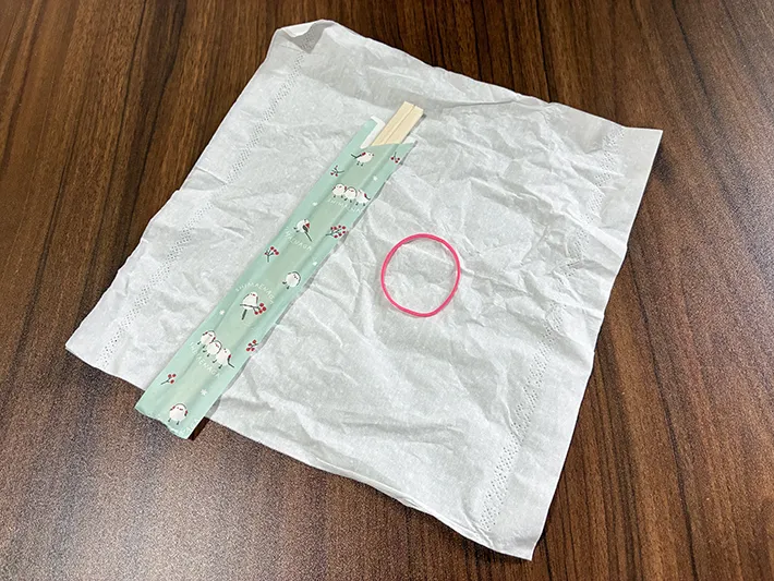 机に置かれたキッチンペーパーと輪ゴム、割り箸（撮影：grapeライフハック編集部）