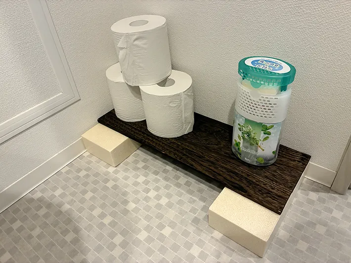 木板の上にのせたトイレットペーパーや消臭剤（撮影：grapeライフハック編集部）