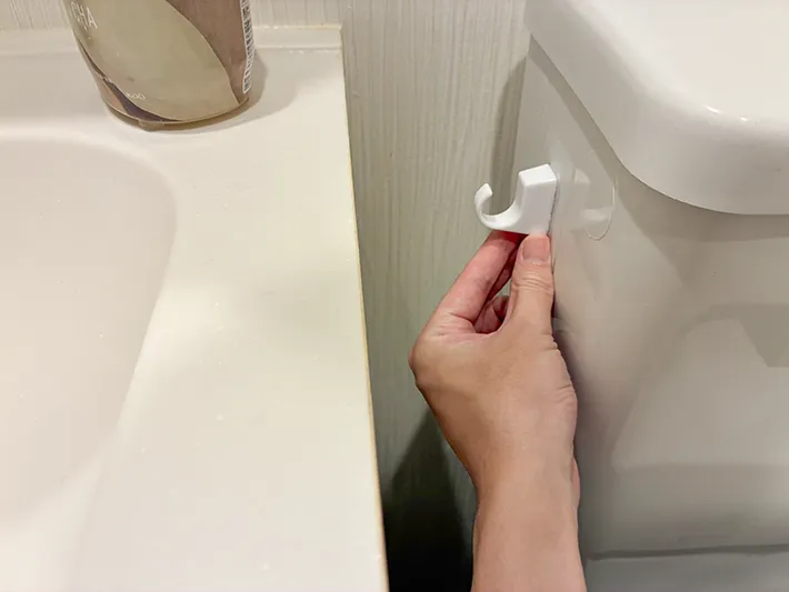 トイレのタンク横に貼った粘着シートフック（撮影：grapeライフハック編集部）