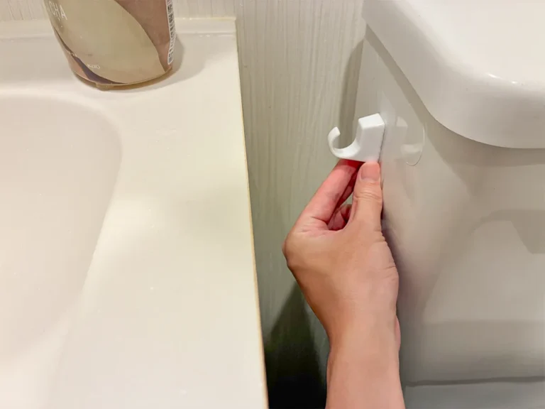 トイレのタンク横に貼った粘着シートフック(撮影:grapeライフハック編集部)