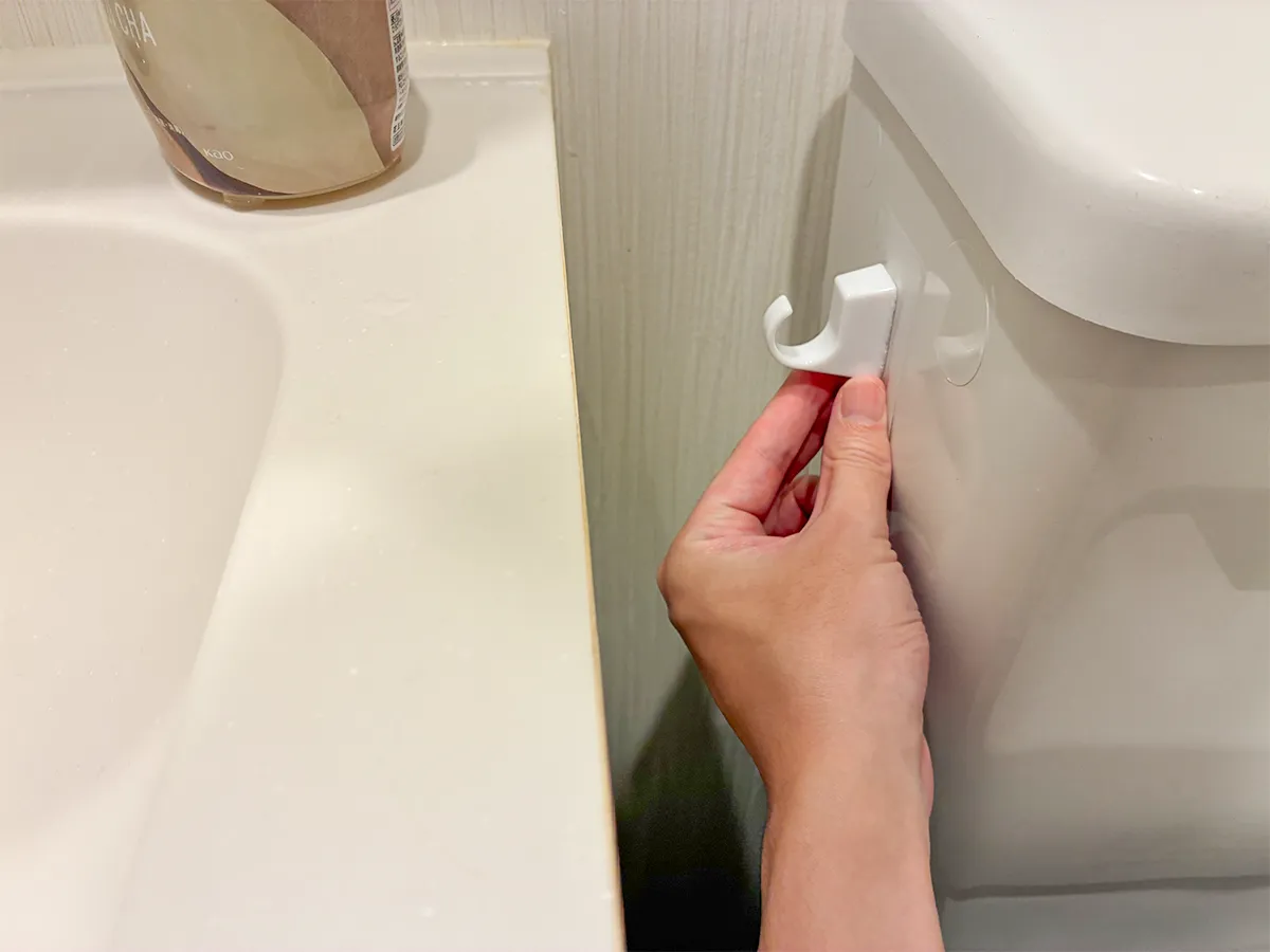 トイレのタンク横に貼った粘着シートフック(撮影:grapeライフハック編集部)