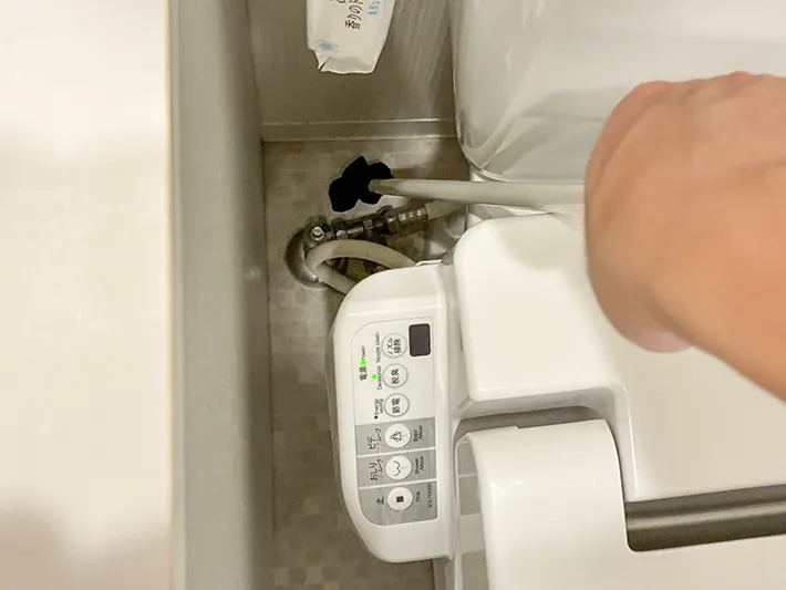 トイレの床を、ヒートテックをつけたつっぱり棒で掃除する場面（撮影：grapeライフハック編集部）