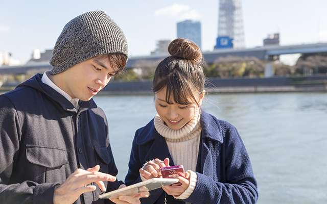 スマホを確認する男女の画像